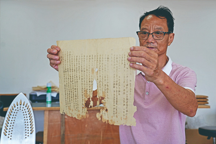 温岭市档案馆修复室中54岁的张仁