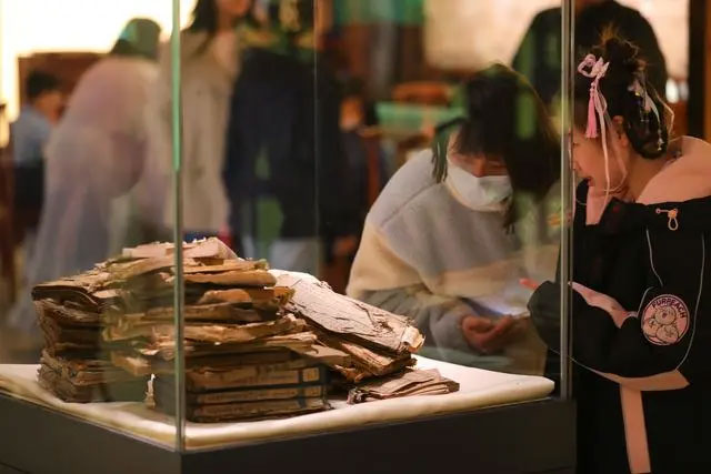 观众在辽宁省图书馆“古籍保护与传承特展”中观看未修复的破损古籍