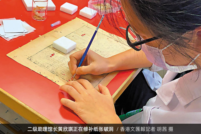 香港中央图书馆二级助理馆长黄欣琪正在修补纸张破洞/香港文匯報記者 胡茜 摄